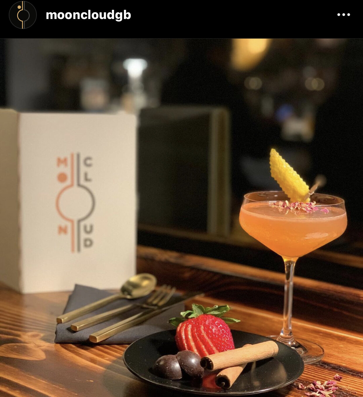 cocktail and dessert on a bar counter with a menu in the background